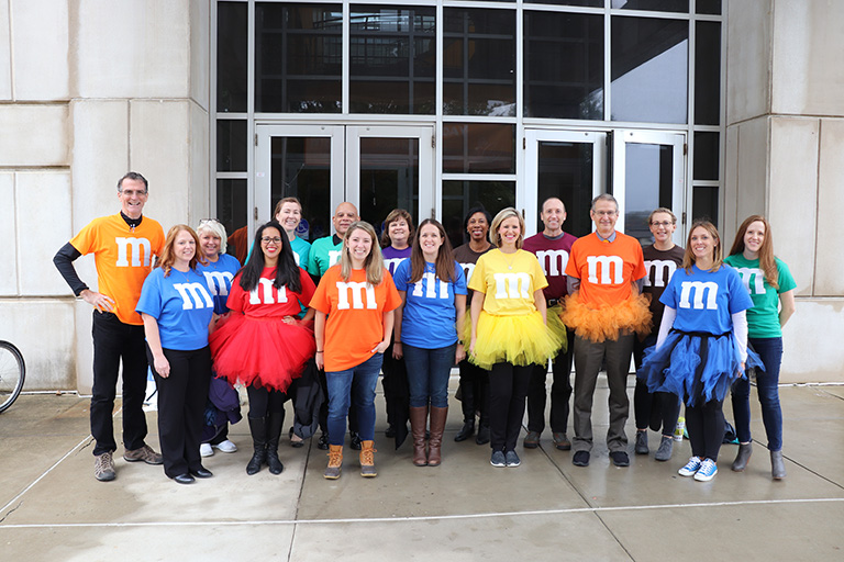 Mark Dean and the TCE administrative staff dressed as the M&M team for the college’s 2018 “Boo in the Courtyard” Halloween spirit event.