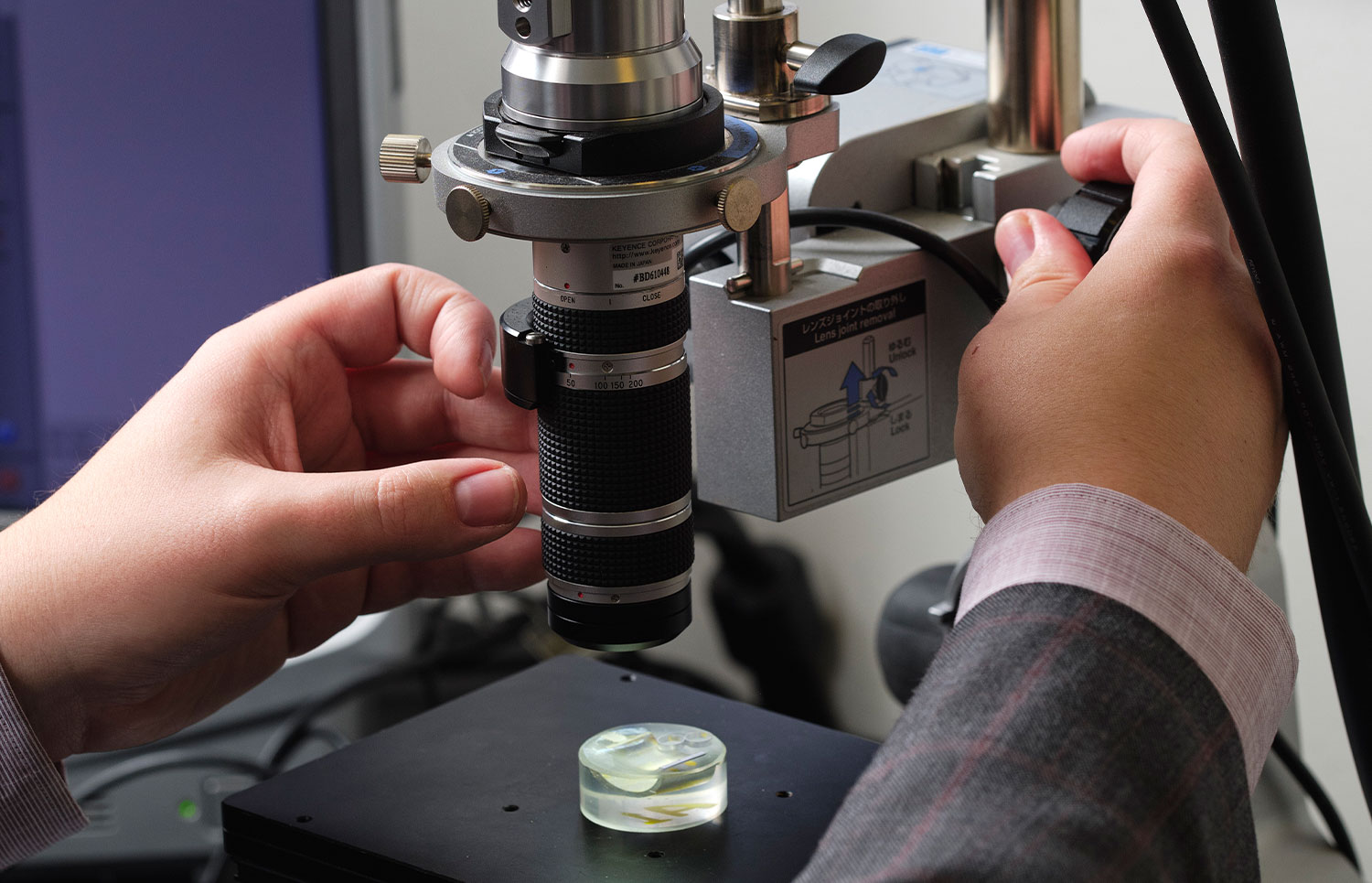 UT Student Looks at Material Under Microscrope at ARC Lab