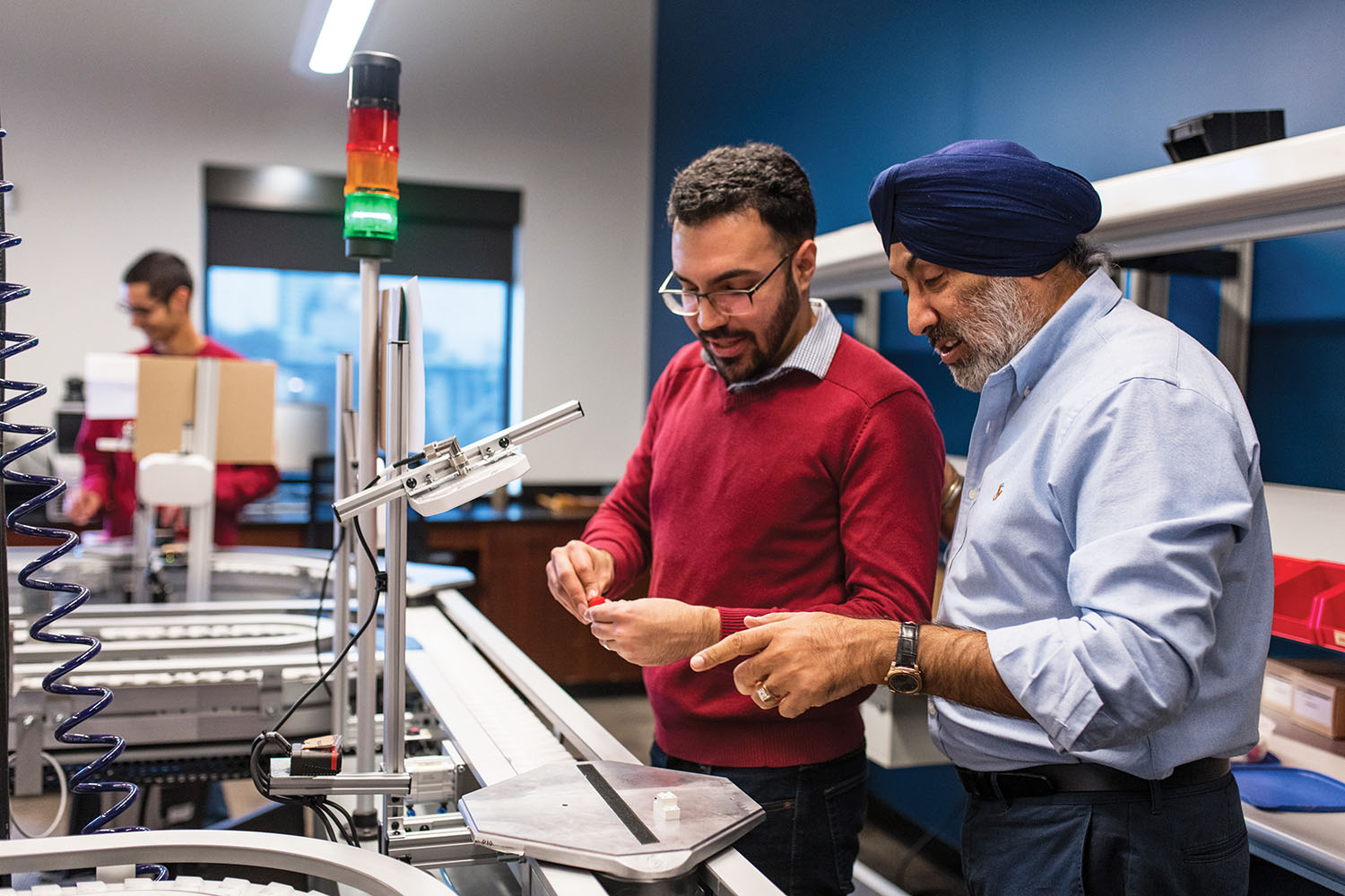 Rupy Sawhney works with a researcher in a lab.