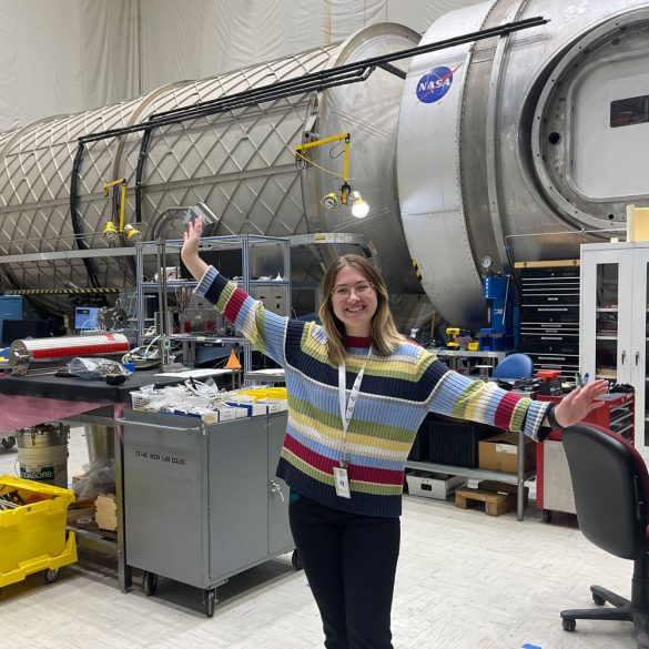 Katie Davis standing in front of Microfluidic Electrochemical Reactor
