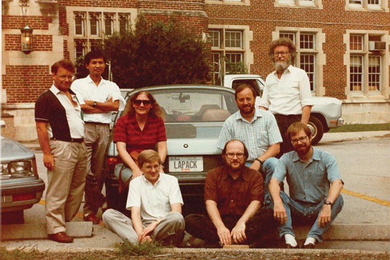 Dongarra poses with members of the group that created the LAPACK software package beside his car with a LAPACK license plate.