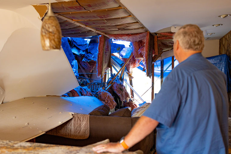 Terry Hazen looking at the damage done on the inside of his house from the tornado.