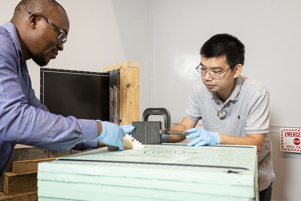 professor and grad student working on the neutron source