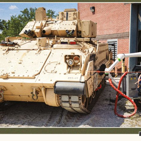 Military service member demonstrates field repairs on vehicle