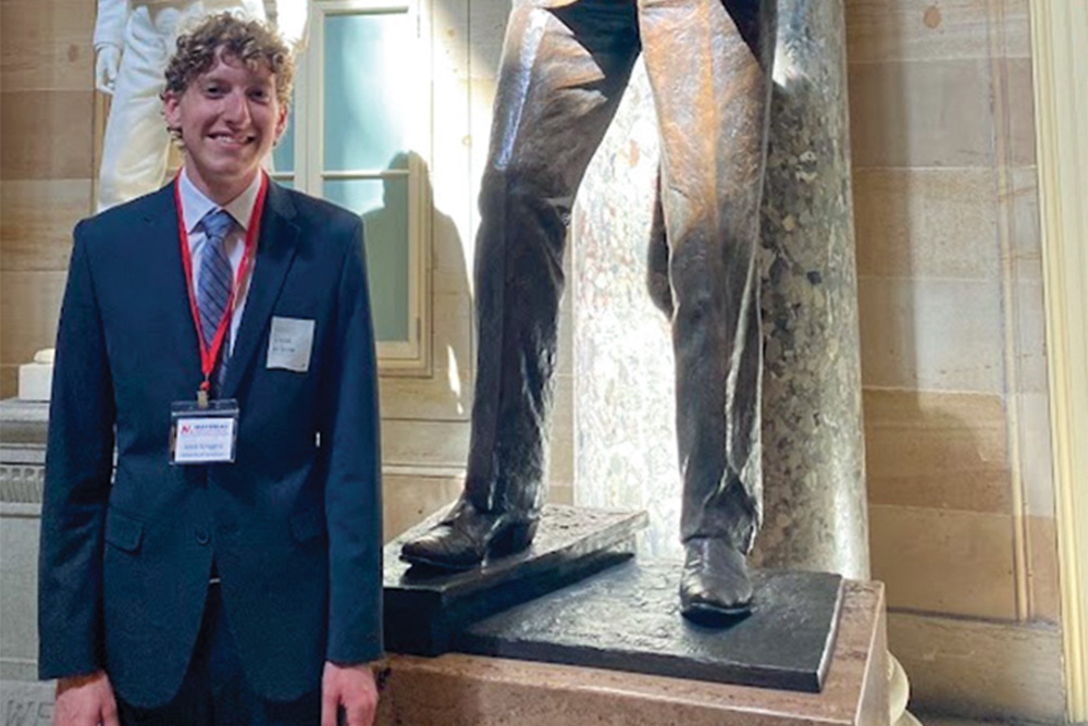 Jakob Scroggins posed next to the statue of Barry Goldwater