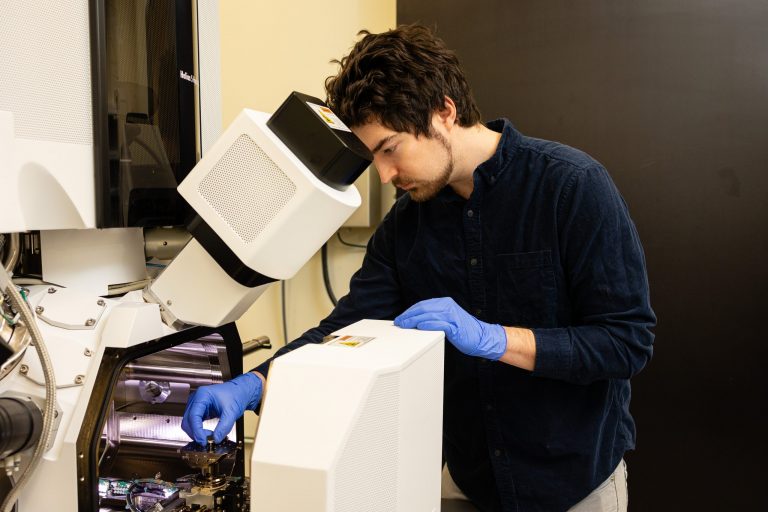 male student working on equipment in Steven Zinkle's lab