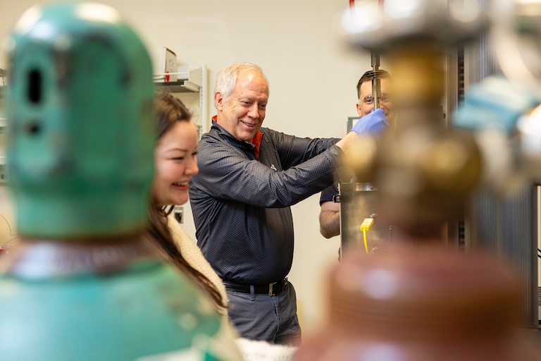 Steven Zinkle working in a lab with students