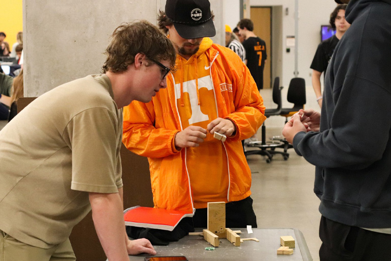 Three EF151 students work on their project