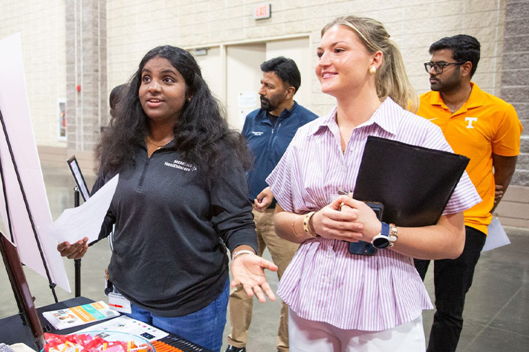 Two students speak with employer at the Engineering Expo