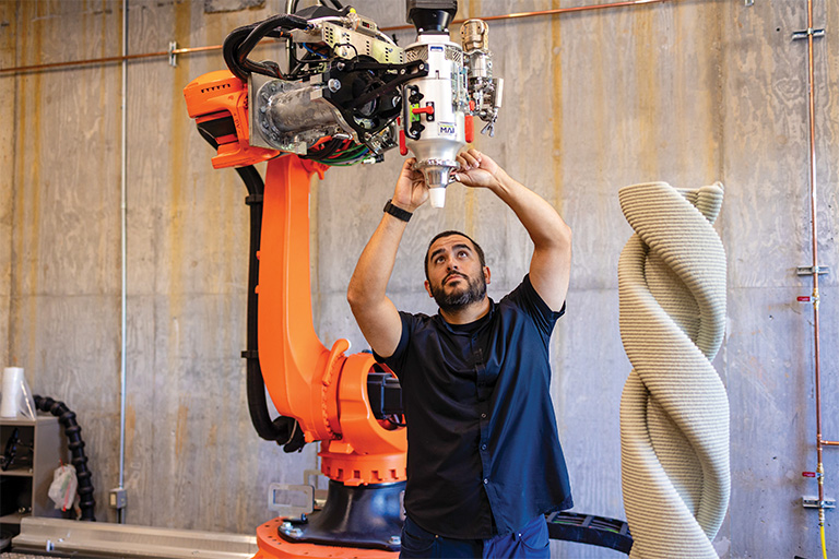 Prado checks on nozzle of 3D extruder