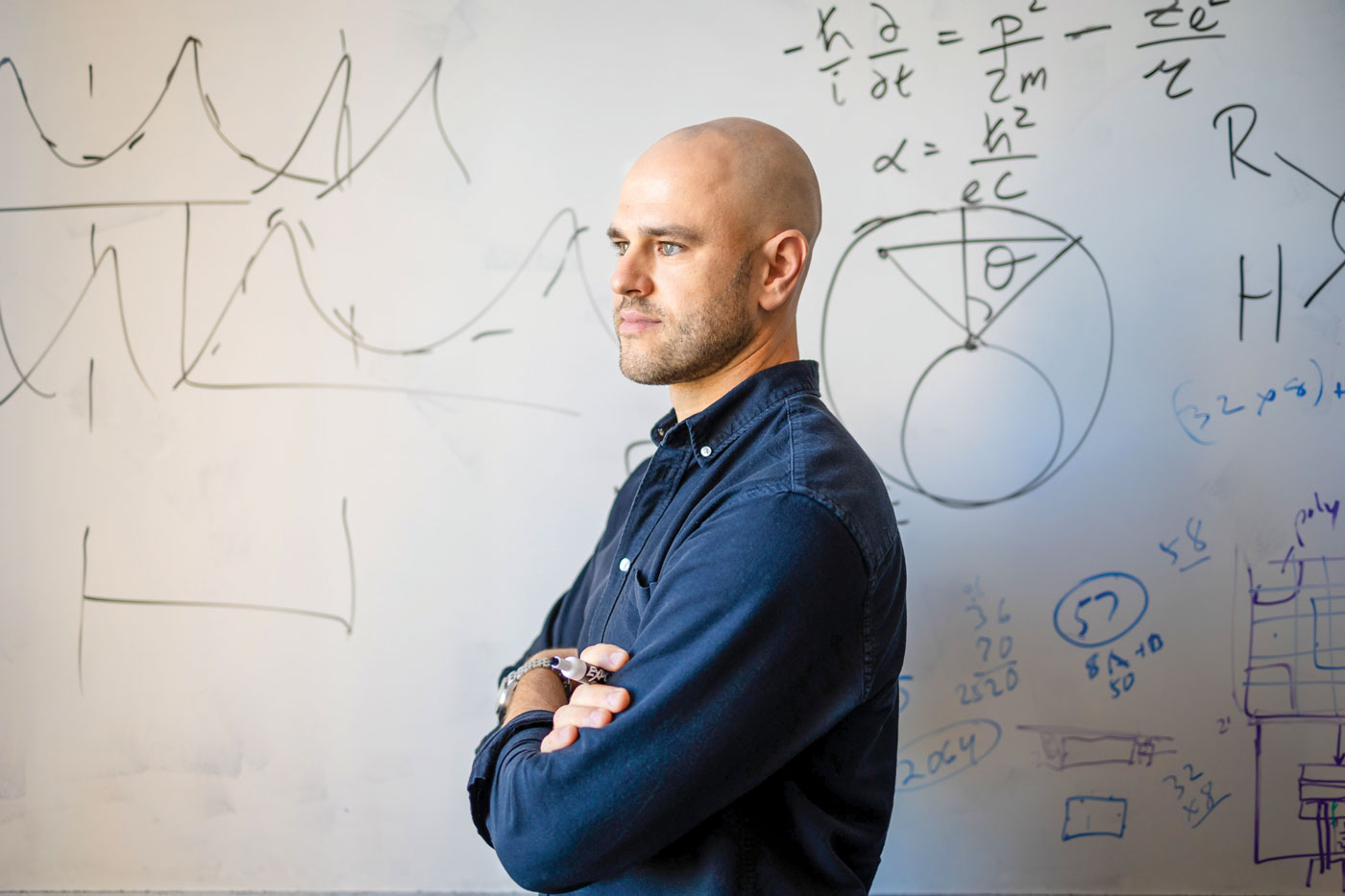 Associate Professor Vlad Sobes standing in front of a whiteboard with drawn charts