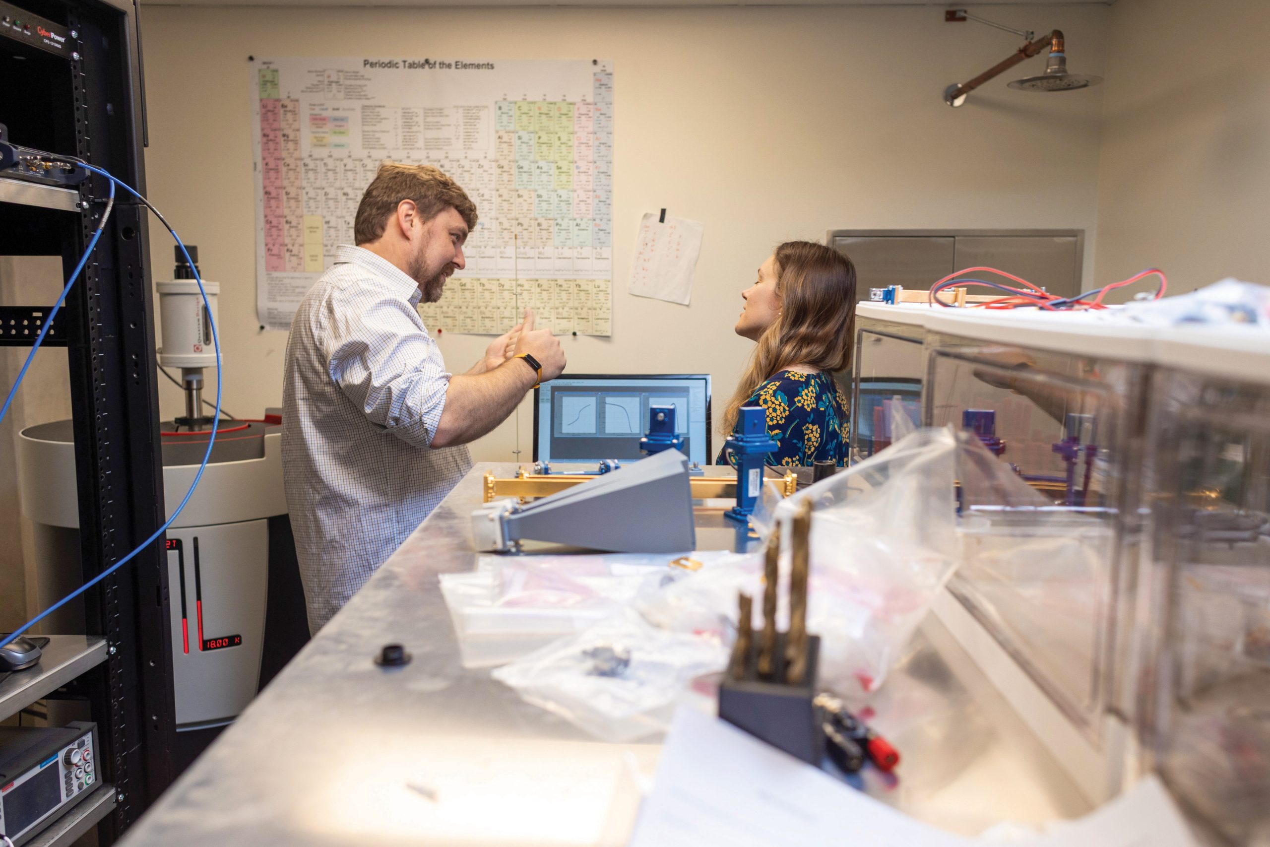 Professors Dustin Gilbert and Anne Murray discuss while observing charts on a computer