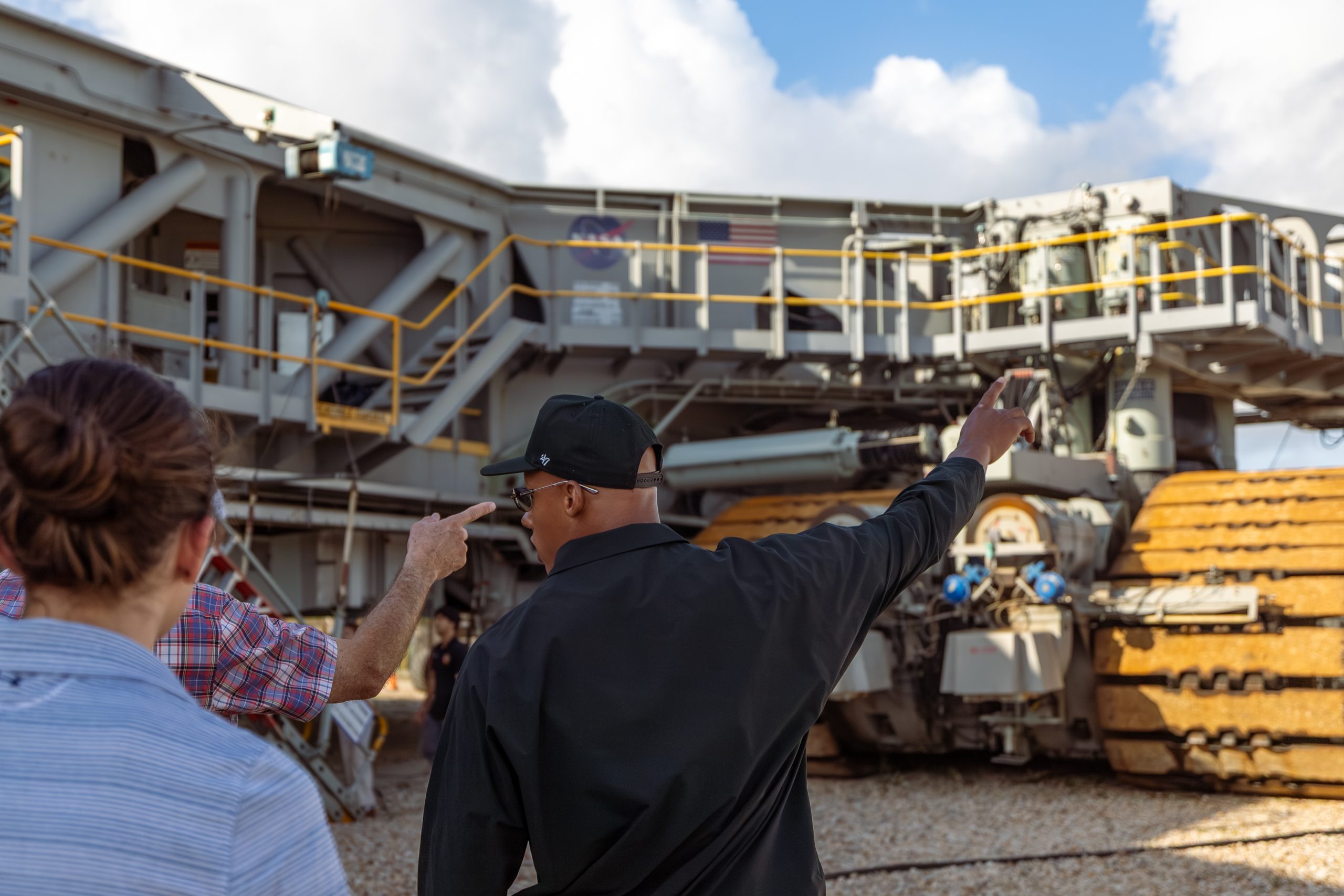 Mechanical and engineering students walk around the NASA campus while pointing at structures