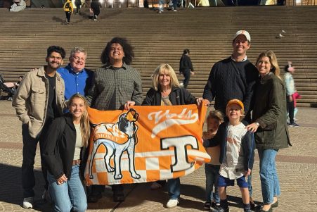Deep Mistry, Anna Witsoe, Darrin Rhines, Connor Davis, Suzanne Sawicki, Ryan Welker, and his family holding a UT flag with Smokey on it.