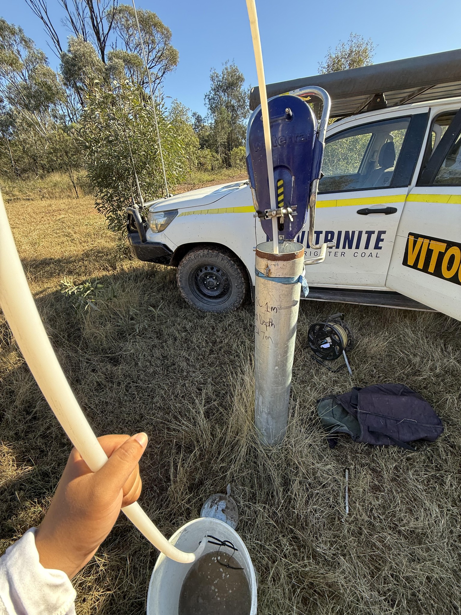 Group member using a water pump to extract water samples from the ground