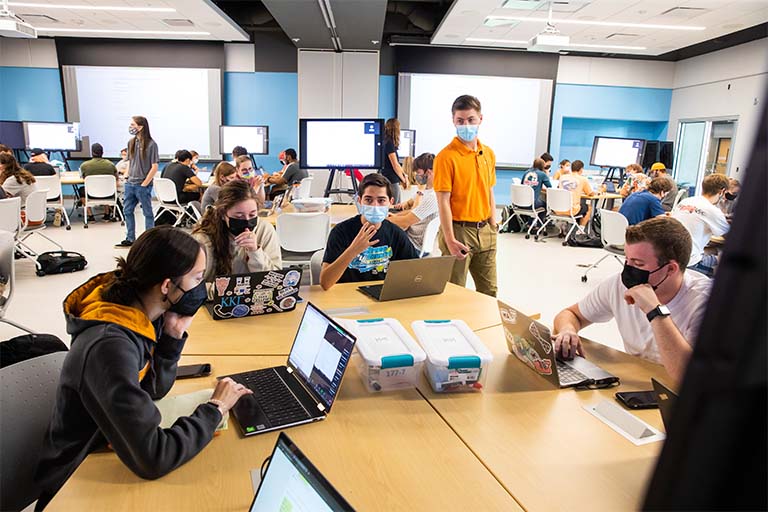 GTA works with students during class