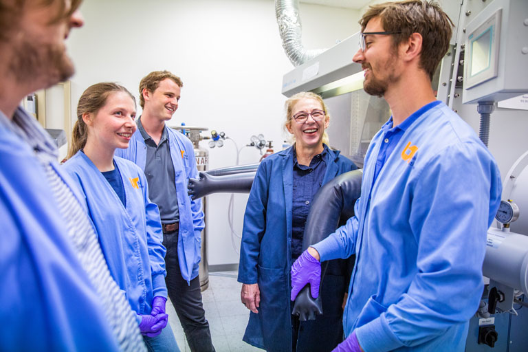 Grad students talking to professor Johnson in her lab