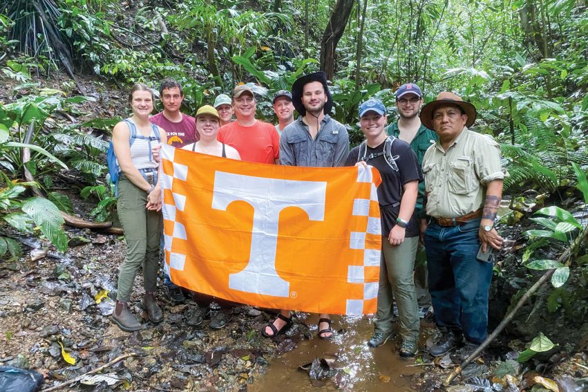 Students posing for picture with University of Tennessee flag in Panama