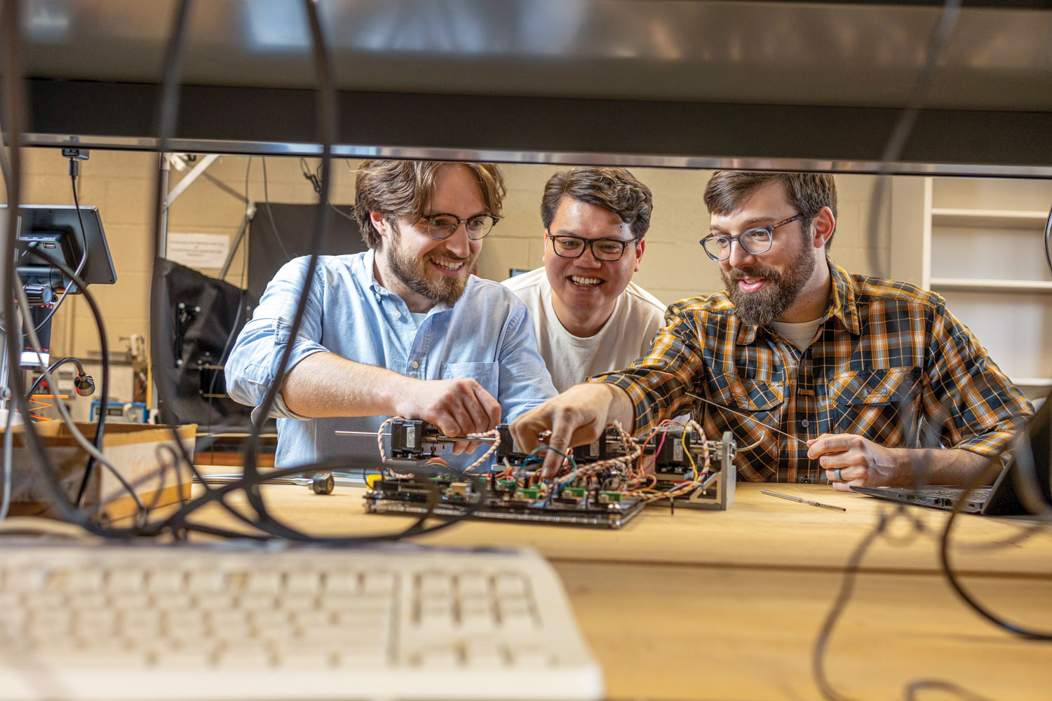 Professor Caleb Rucker working in the lab with PhD students Khoa Dang and Joshua Gaston