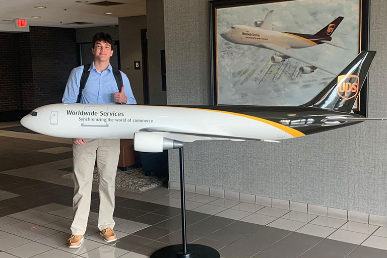 Chris giving thumbs up by a UPS plane replica