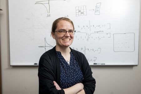 Catherine Schumann standing in front of a whiteboard