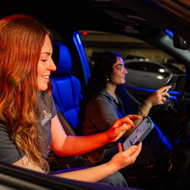Students in car looking at parking app