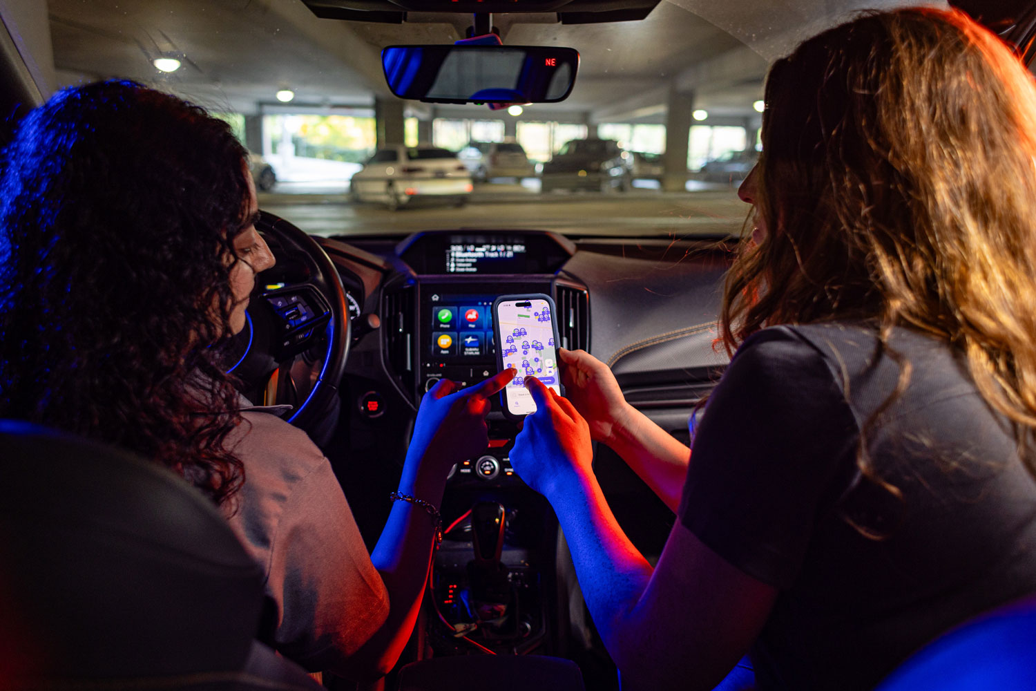 Students in car looking at parking app